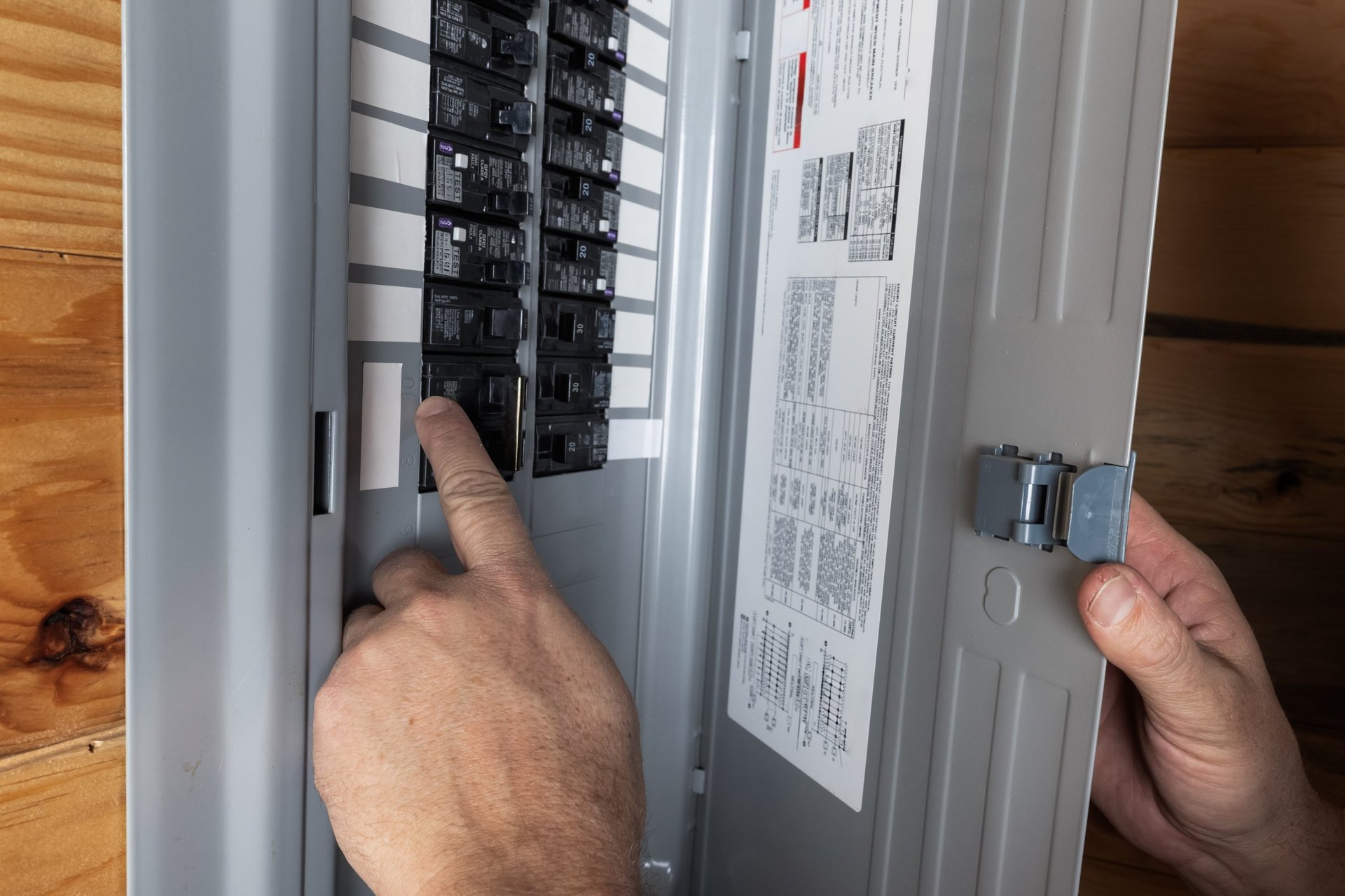 Home owner inspecting electrical breakers or fuse box